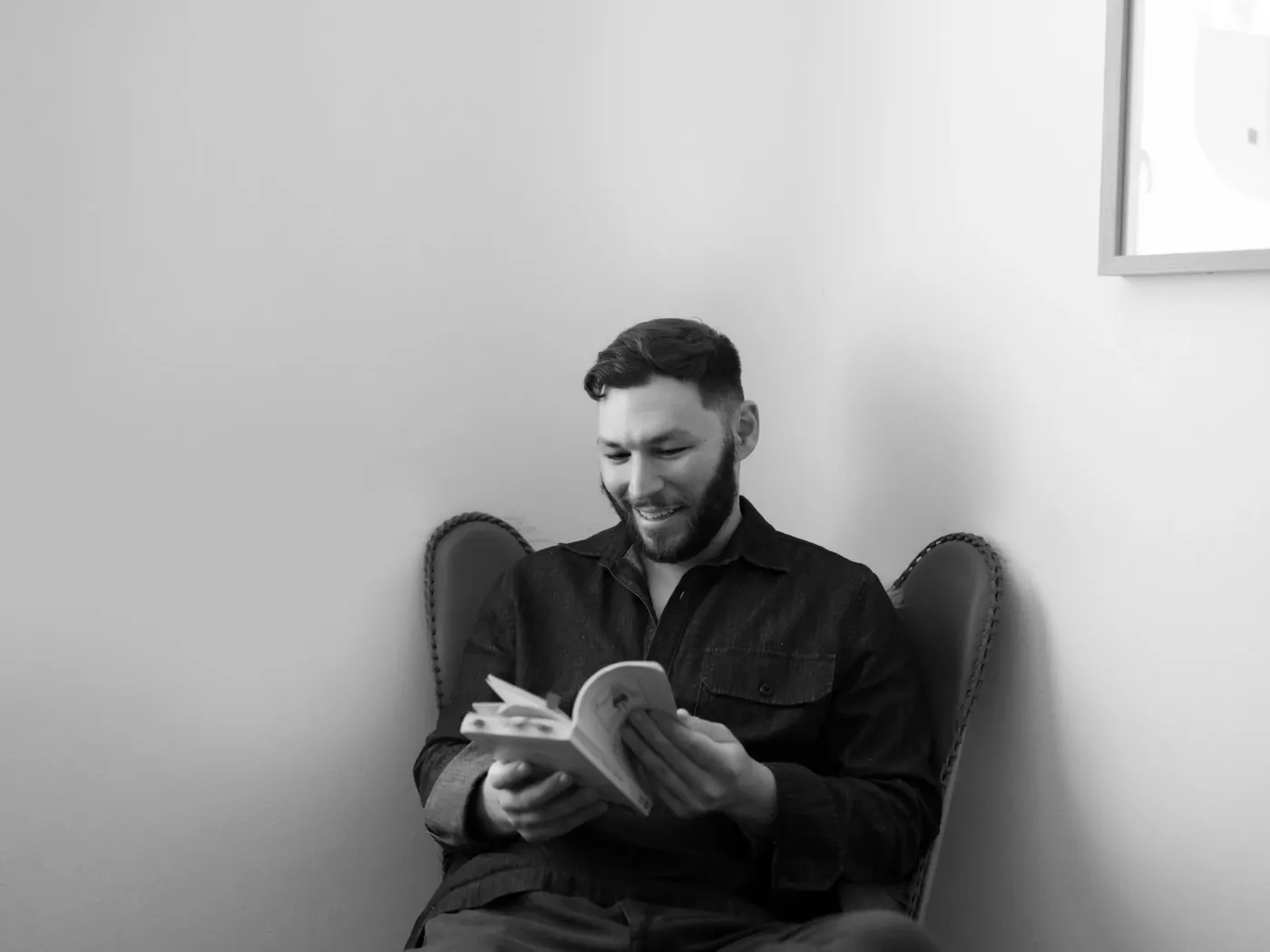 Michael Robin reading in an armchair